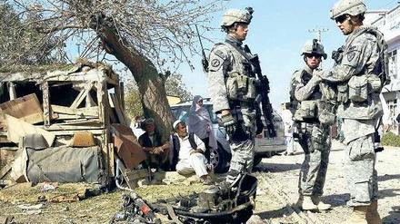 Blutiger Alltag. US-Soldaten stehen am Sonntag vor den Trümmern, die eine Explosion vor dem Hauptquartier der Polizei in Kandahar hinterlassen hat. Bei dem Anschlag wurde mindestens ein Mensch getötet. Foto: Ahmad Nadeem/Reuters