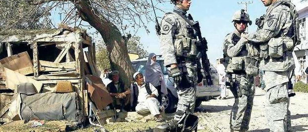 Blutiger Alltag. US-Soldaten stehen am Sonntag vor den Trümmern, die eine Explosion vor dem Hauptquartier der Polizei in Kandahar hinterlassen hat. Bei dem Anschlag wurde mindestens ein Mensch getötet. Foto: Ahmad Nadeem/Reuters