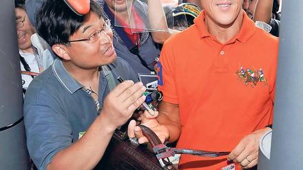 Außerhalb des Wagens macht er noch eine gute Figur. Michael Schumacher erreicht unter reger Anteilnahme der örtlichen Bevölkerung die Rennstrecke von Suzuka. Foto: dpa