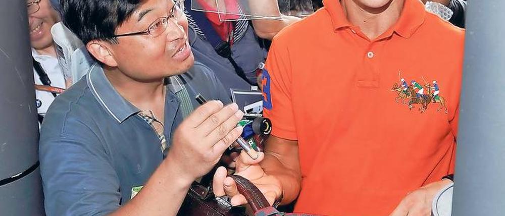 Außerhalb des Wagens macht er noch eine gute Figur. Michael Schumacher erreicht unter reger Anteilnahme der örtlichen Bevölkerung die Rennstrecke von Suzuka. Foto: dpa