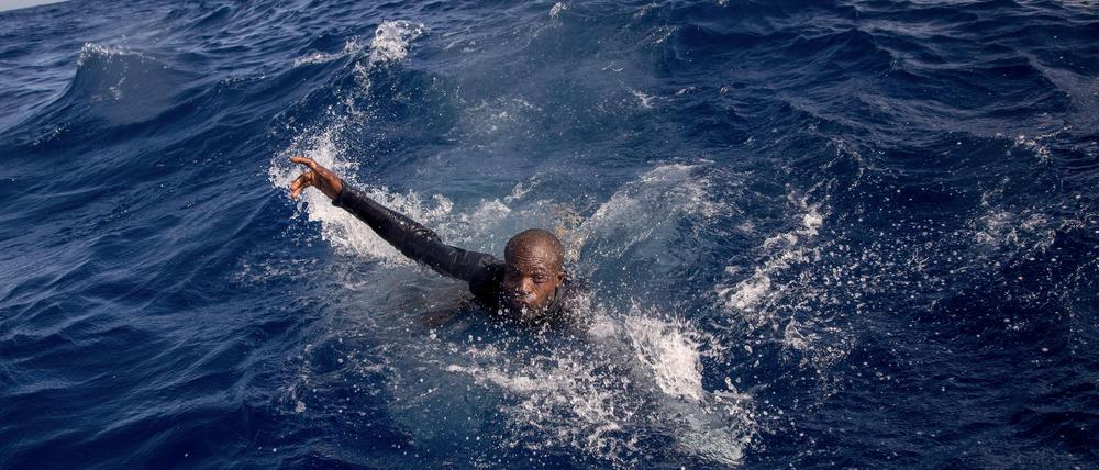 Ein Flüchtling versucht, im Mittelmeer auf das Boot einer deutschen Nichtregierungsorganisation zu gelangen. 