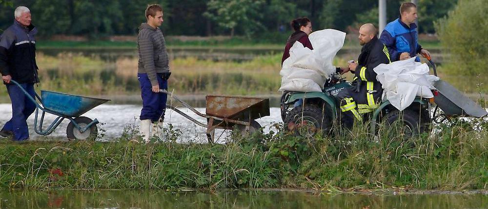 Helfer kämpfen gegen die Wassermassen. Bei Saathain zwischen Elsterwerda und Bad Liebenwerda werden die Dämme verstärkt.