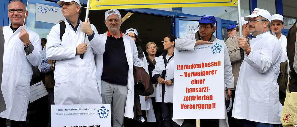 Ärzteprotest: Ärzte zeigen am in Essen vor der Grugahalle Protestplakate. 