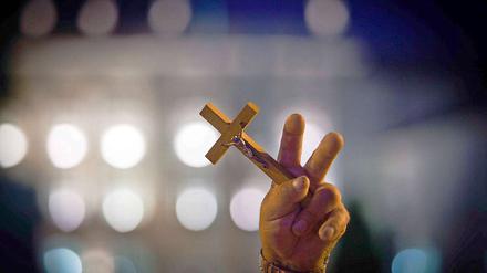 Mit religiöser Hingabe. Die Demonstranten wollen nicht hinnehmen, dass das große Holzkreuz in einer Kirche gebracht wird.