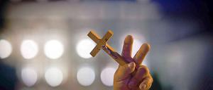 Mit religiöser Hingabe. Die Demonstranten wollen nicht hinnehmen, dass das große Holzkreuz in einer Kirche gebracht wird. 