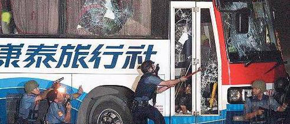 Mit Hammerschlägen versucht ein Polizist, die Tür einzuschlagen. Foto: dpa