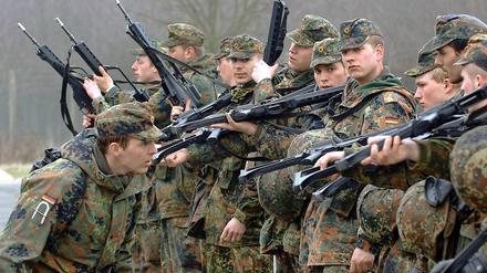 Ein Ausbilder der Bundeswehr überprüft auf einem Truppenübungsplatz in Ahlen die entleerten Waffen der Rekruten in der Grundausbildung.
