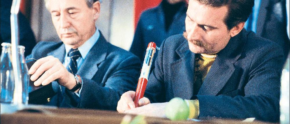 Mit dem Papst in der Hand. Lech Walesa unterschreibt am 31. August 1980 mit einem Riesenkuli, auf dem Johannes Paul II. abgebildet ist, die Anerkennung der Solidarnosc zur Gewerkschaft. Zu seiner Rechten KP-Funktionär Mieczyslaw Jagielski.Foto: Eyedea Presse/laif