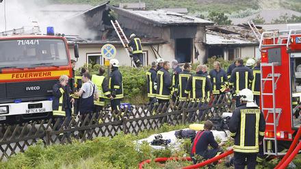 Feuerwehrleute stehen Am Montag den 16. August brannte auf der Nordseeinsel dieses Haus aus.