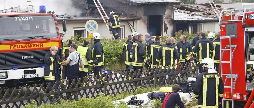 Feuerwehrleute stehen Am Montag den 16. August brannte auf der Nordseeinsel dieses Haus aus.