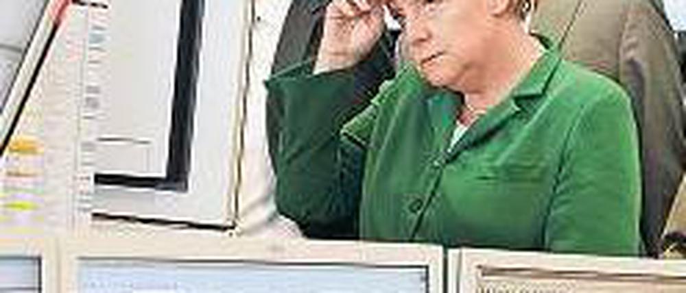 Auf dem Schirm. Merkel ließ sich gestern den Handelsraum der EEX erklären.Foto: dpa