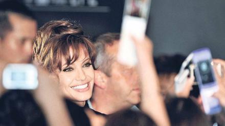 Eine Frau mit Vergangenheit. Hinter der strahlenden Fassade verbergen sich dunkle Abgründe – so sieht Biograf Andrew Morton die Schauspielerin Angelina Jolie, die hier bei der „Salt“-Premiere vergangene Woche in Tokio zu sehen ist. In Berlin wird sie den Thriller am 18. August präsentieren. Foto: dpa