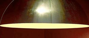 Ein Besucher nähert sich an eine Lampe von Ingo Maurer auf einer Ausstellung 2005. Maurer wird auch als "Poet des Lichts" bezeichnet.