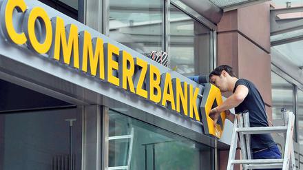 Die ersten Commerzbank-Filialen erhalten das neue gemeinsame Logo, das das grüne Band der Dresdner-Bank und das alte Commerzbank-Emblem ersetzt.