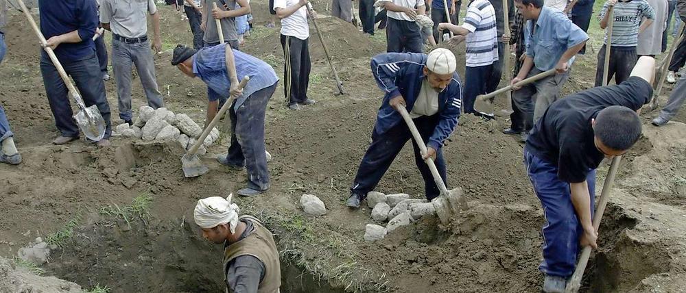 Usbeken heben in der kirgisischen Stadt Osch Gräber aus.