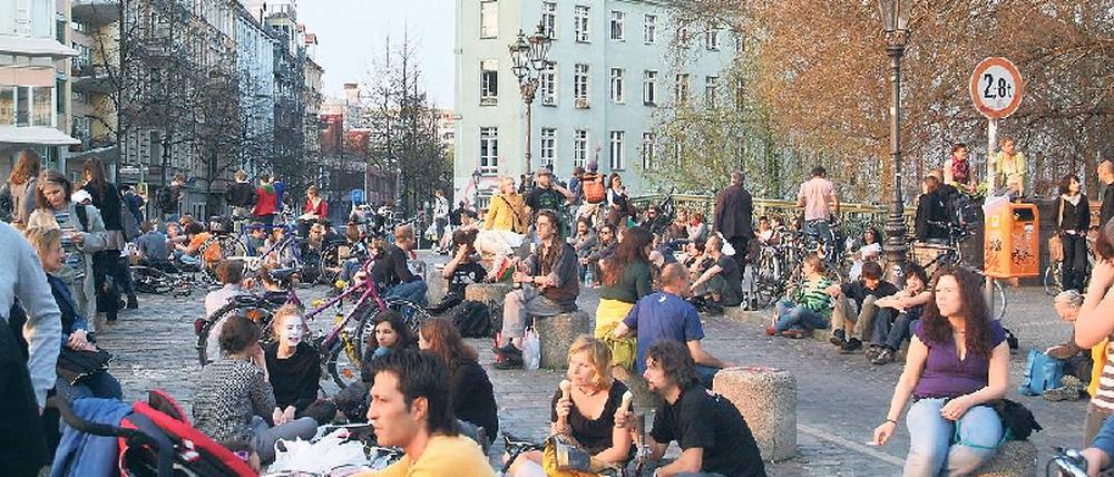 Sitzblockade. Die Kreuzberger Admiralbrücke steht mittlerweile in vielen Reiseführern. Bis spät in die Nacht bevölkern Feiernde die Gehwege und die Fahrbahn. Foto: Kai-Uwe Heinrich