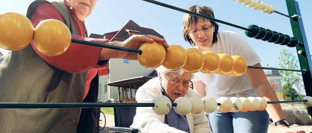 Den Kopf trainieren. Heimbewohnerinnen an einer riesigen Rechentafel. Foto: p-a/zb
