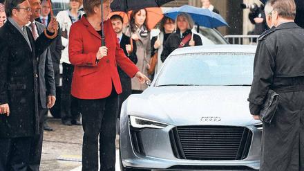 Autos von morgen. Bundeskanzlerin Angela Merkel besichtigte am Montag im strömenden Regen vor dem Brandenburger Tor die "Technikschau" der deutschen Automobilindustrie und ihrer Zulieferer. Mit dabei: die Elektrostudie "E-tron" von Audi.