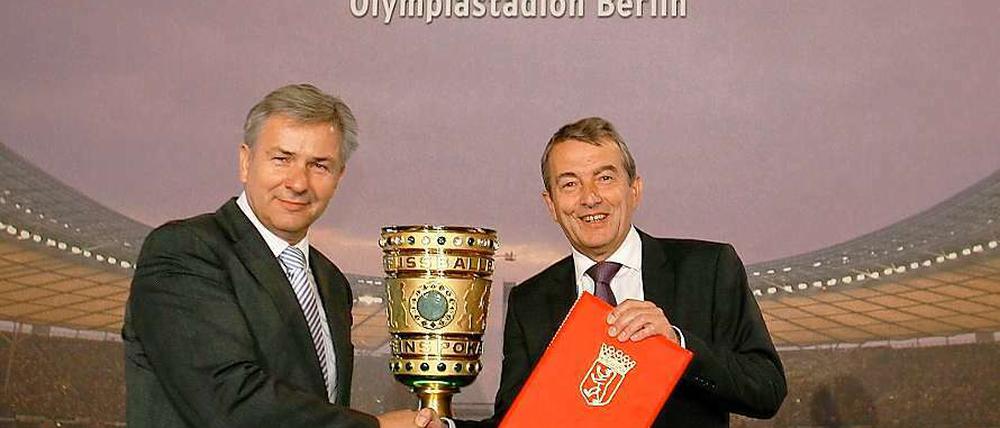 Berlins Regierender Bürgermeister Klaus Wowereit, der Generalsekretär des Deutschen Fußball Bundes (DFB), Wolfgang Niersbach - und der DFB-Pokal.