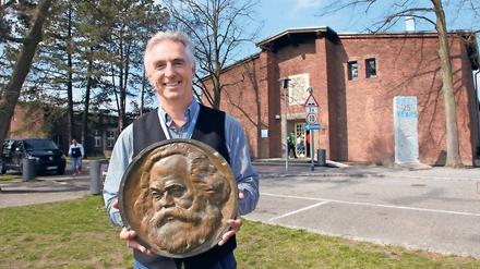 Gesichert. BBIS-Schulleiter Burkhard Dolata lagert die noch erhaltene Marx-Plakette im Safe der Schule. Sie ist alles, was vom Denkmal (r.) noch übrig ist.