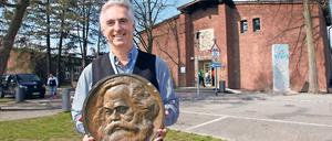 Gesichert. BBIS-Schulleiter Burkhard Dolata lagert die noch erhaltene Marx-Plakette im Safe der Schule. Sie ist alles, was vom Denkmal (r.) noch übrig ist.