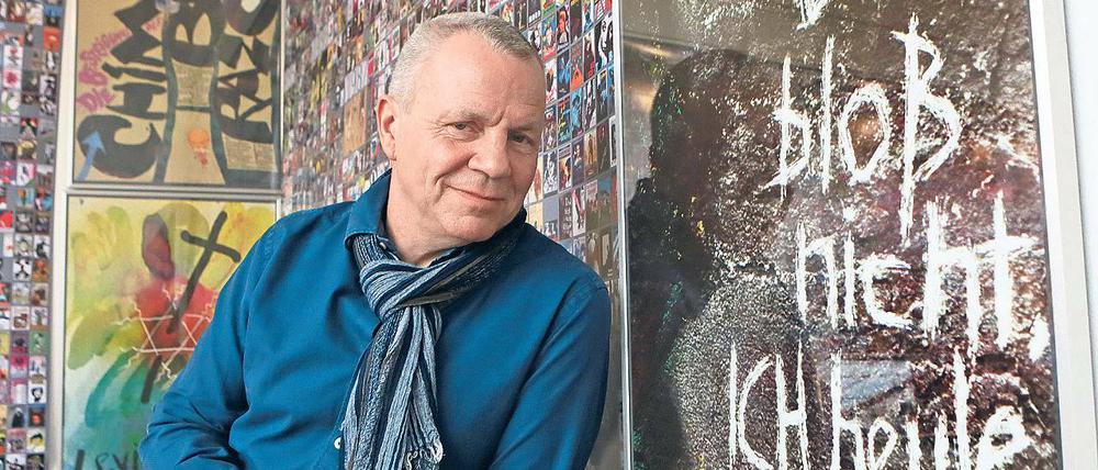 Vor seinem Plakat. Der Grafiker Detlef Helmbold hat die Ausstellung kuratiert.