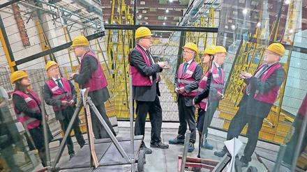 Zu Besuch. Brandenburgs Wirtschaftsminister Albrecht Gerber (SPD, M.) und die SPD-Bundestagsabgeordnete Manja Schüle (r.) ließen sich von Saint-Gobain-Glassolutions- Geschäftsführer Ingolf Ripberger (l.) zum neuen knallgelben Lastkran führen, der unter der Decke der Halle hin- und herfahrbar ist.