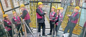 Zu Besuch. Brandenburgs Wirtschaftsminister Albrecht Gerber (SPD, M.) und die SPD-Bundestagsabgeordnete Manja Schüle (r.) ließen sich von Saint-Gobain-Glassolutions- Geschäftsführer Ingolf Ripberger (l.) zum neuen knallgelben Lastkran führen, der unter der Decke der Halle hin- und herfahrbar ist.