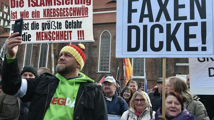 Brandenburg, Cottbus: Ein Demonstrant filmt mit dem Handy die Plakate auf dem Oberkirchplatz. Der Verein Zukunft Heimat e.V. hatte zu der Demonstration aufgerufen.