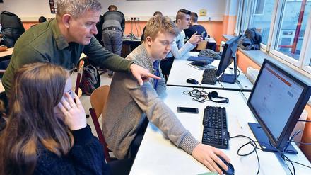 Eigenständig lernen. Lehrer Björn Nölte (l.) erklärt Schülern der elften Klasse der Voltaire-Schule eine individuelle Aufgabenstellung auf einem Computer. Die digitalen Lehrmittel sollen den Unterricht bereichern, doch oft sind zu wenig Computer und eine langsame Internetverbindung an den Schulen vorhanden.
