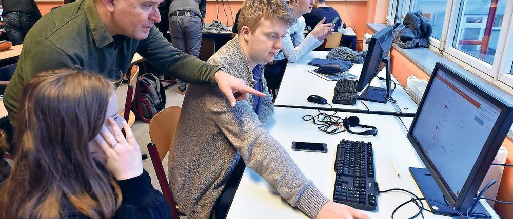 Eigenständig lernen. Lehrer Björn Nölte (l.) erklärt Schülern der elften Klasse der Voltaire-Schule eine individuelle Aufgabenstellung auf einem Computer. Die digitalen Lehrmittel sollen den Unterricht bereichern, doch oft sind zu wenig Computer und eine langsame Internetverbindung an den Schulen vorhanden.