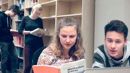 Leseratten. Bei der Eröffnung stöberten die Schüler des Helmholtz-Gymnasiums in den Büchern und probierten die neuen Laptops. Einige Regale stehen noch leer.