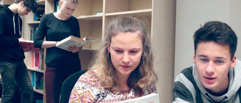 Leseratten. Bei der Eröffnung stöberten die Schüler des Helmholtz-Gymnasiums in den Büchern und probierten die neuen Laptops. Einige Regale stehen noch leer.