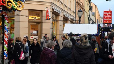 Passanten stehen am Samstag in Potsdam auf dem Weihnachtsmarkt an der Apotheke, in der am Vortag ein verdächtiges Paket abgegeben worden war. Darin befanden sich Hunderte Nägel und ein sogenannter Polenböller.