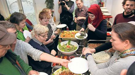 Vorbehalte abbauen. Bei Couscous, gefüllten Weinblättern und Hummus kamen Flüchtlinge und bedürftige Besucher der Suppenküche ins Gespräch.