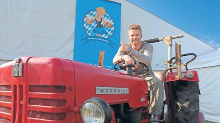 Stimmungsexperte. Heiko Bengs, Veranstalter vom Oktoberfest, auf dem Wiesn-Traktor vor dem Festzelt. Auch Gäste dürfen dort hoch und Fotos machen.