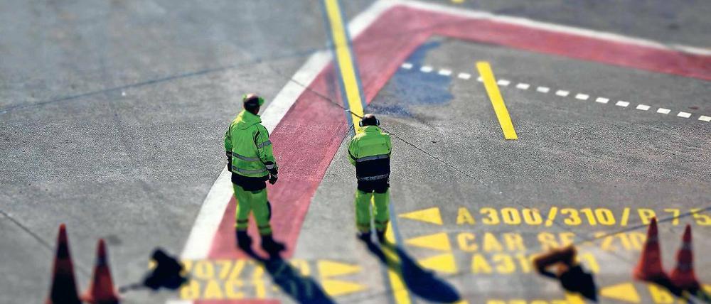 Darf hier weiter geflogen werden? Mitarbeiter des Flughafens Tegel beim Einweisen einer gelandeten Maschine.