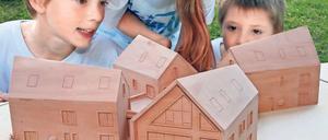Neues Zuhause. Die Kinder bestaunen das Modell des geplanten Heimes.