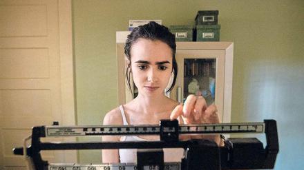 Ellen (Lily Collins) muss feststellen, dass sie weiter an Gewicht verlieren. Szene aus dem Netflix-Film "To the Bone".