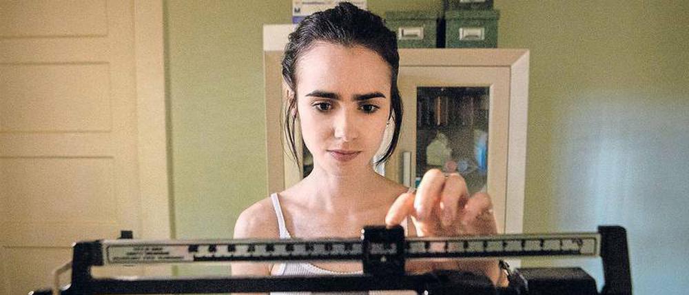 Ellen (Lily Collins) muss feststellen, dass sie weiter an Gewicht verlieren. Szene aus dem Netflix-Film "To the Bone".