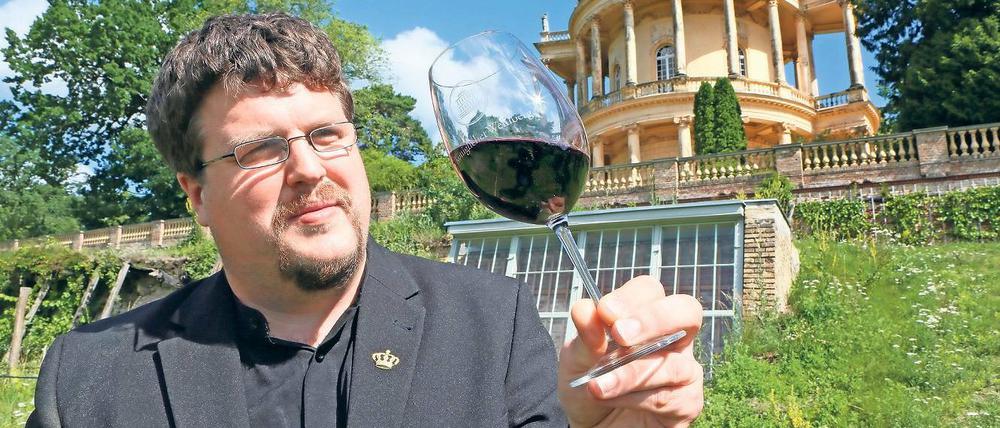 Frisch und köstlich. Andreas Kramp ist der Sprecher der Berliner Mosaik-Werkstätten für Behinderte, die den Königlichen Weinberg in Kooperation mit der Schlösserstiftung restaurieren. Er testet den erst kürzlich abgefüllten Rotwein der Sorte Regent. Im Hintergrund ein Stück wiederhergestellter Talutmauer.