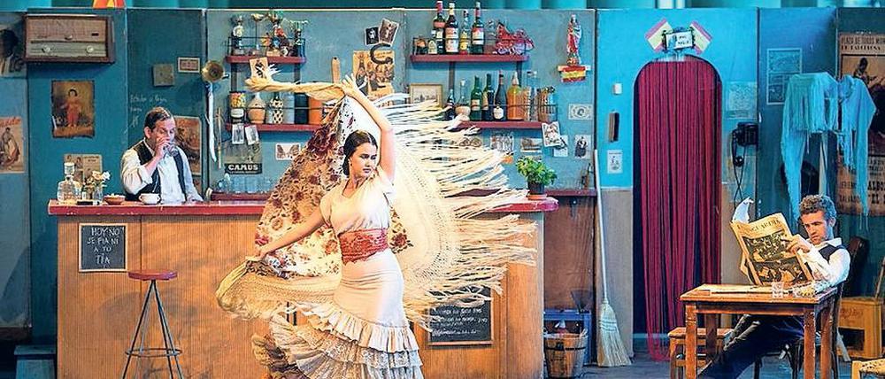 Parodie von Klischees. Die Inszenierung war in einer volkstümlichen spanischen Bar der 1950er Jahre angesiedelt. Der Barmann gab Wein aus und warf bisweilen mit Oliven.