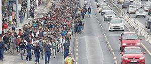 Tausende Menschen gehen über die Autobahn zur österreichischen Grenze.