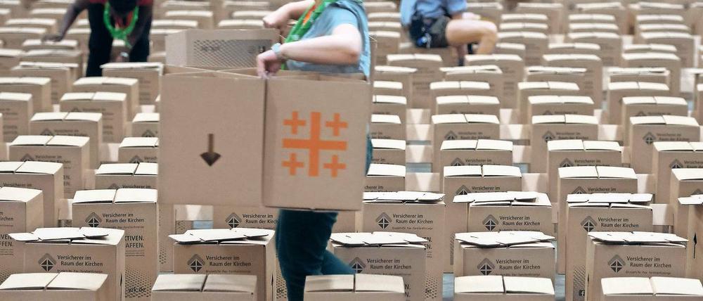 Es ist bestuhlt. 30 000 Papphocker sind für den Kirchentag als Sitzgelegenheiten vorgesehen, ein Teil davon wird derzeit in der Messehalle 25 aufgebaut. Nach dem Wochenende werden sie für einen Euro pro Karton verkauft.