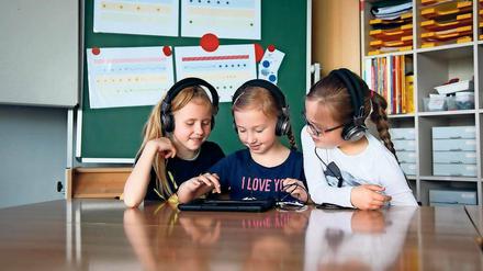 An der Soundmaschine. Amy, Laura und Livia von der Rosa-Luxemburg- Grundschule beim Komponieren. An der Tafel hängen bereits fertige Partituren.