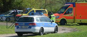 Polizei- und Rettungsfahrzeuge am Rand einer Straße bei Priort (Havelland). Dort sind am Montag zwei männliche Leichen in einem Auto entdeckt worden.