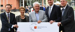 Während der Festveranstaltung zur Eröffnung der neuen Digital Engineering Fakultät an der Universität Potsdam halten der Präsident der Universität Potsdam, Oliver Günther, die brandenburgische Wissenschaftsministerin Martina Münch (SPD), der Präsident des Plattner Institutes, Hasso Plattner, der brandenburgische Ministerpräsident Dietmar Woidke (SPD) und der Institutsdirektor des Plattner-Institutes Christoph Meinel (l-r) das neue Logo der Fakultät.