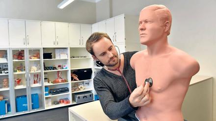 Tief durchatmen. Fabian Schipmann horcht im Gebäude des neuen zweiten Standortes der Medizinischen Hochschule Brandenburg eine Trainingsfigur mit einem Stethoskop ab.