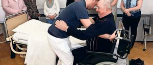 Wie helfen? Im Pfiff-Kurs zeigen Profis pflegenden Angehörigen, wie Pflege praktisch geht. Zum Beispiel, wie man jemandem in den Rollstuhl hilft.