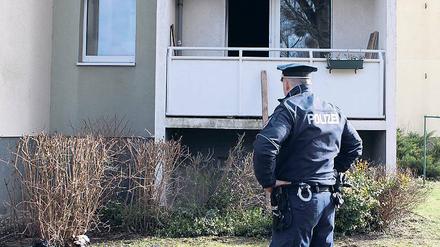 Ausgebrannt. Polizist vor der betroffenen Wohnung am Humboldtring.